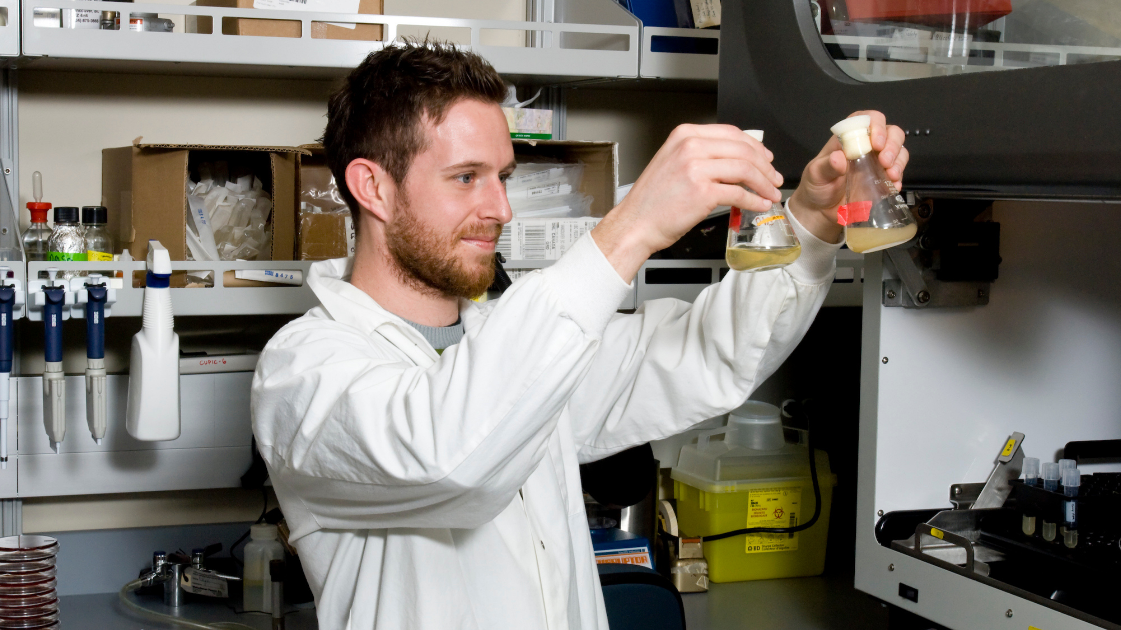 CF Canada researcher holding up two test tubes