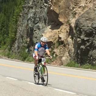 A rider passing in front of a rock face