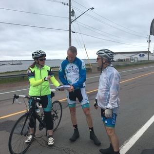 Three cyclists stopped by the side of the road