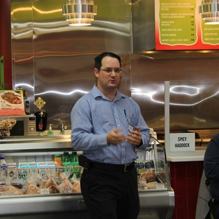 A man talking in front of a fridge counter