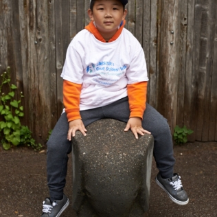 a boy riding a small stone elephant