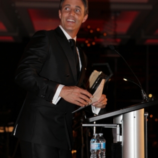 a man smiling behind a lectern