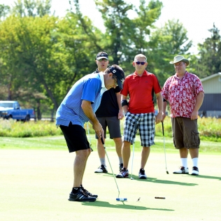 a golfer about to putt in front of others