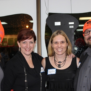Four people, two of whom are wearing orange tuques
