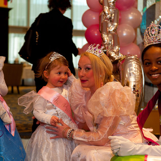 A closeup of two children with two princesses