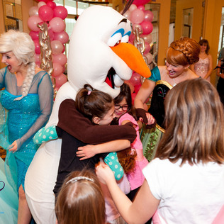 Olaf from Frozen hugging a couple of girls