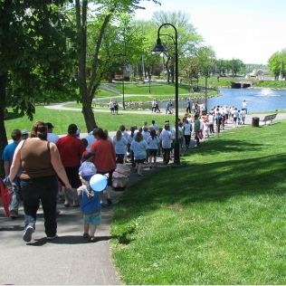 A large group walking down a path to a pond