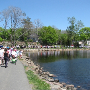 A group of people walking along a path by the water